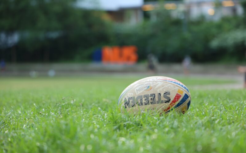 En rugbyboll ligger i gräset.