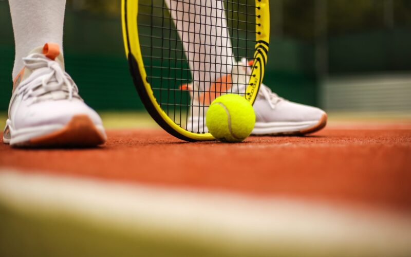 Närbild på ett tennisracket och en tennisboll.